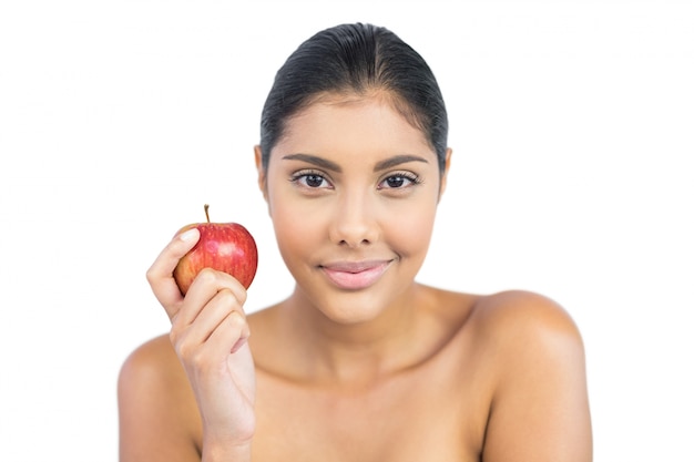 Agradable morena desnuda con manzana roja