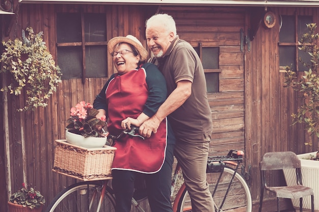 Los agradables caucásicos disfrutan del ocio al aire libre tanto en una sola bicicleta como locos. juntos momentos divertidos en casa afuera. filtro vintage y colores para el concepto alegre y risa