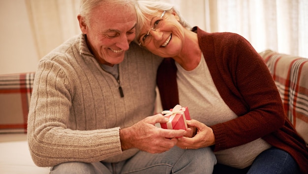 Agradecido por el amor en Navidad Foto de una pareja mayor intercambiando regalos en Navidad