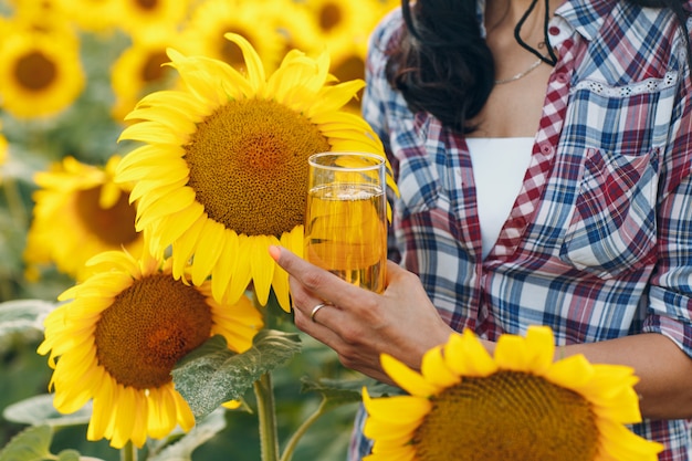 Agricultor con aceite de girasol en el campo de girasoles