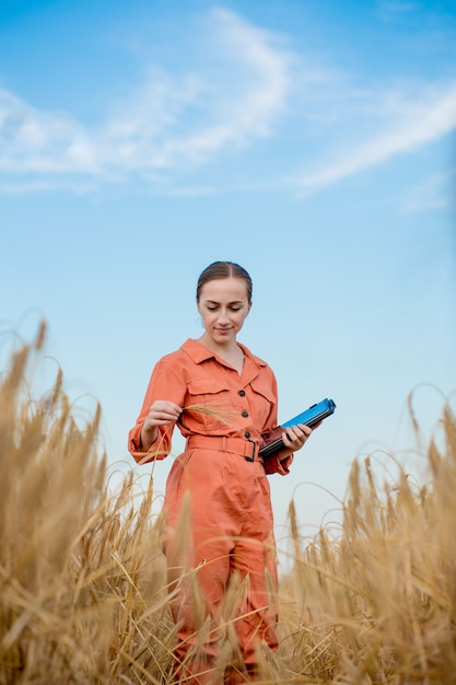 Agricultor agrônomo com computador tablet digital em campo de trigo usando aplicativos e internet smart agriculture