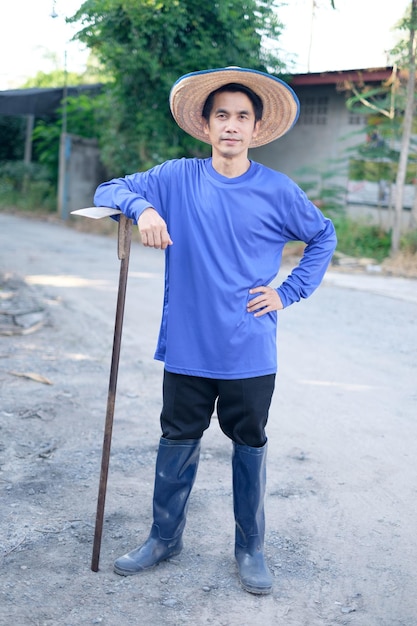 Agricultor asiático em pé e sorrir em casa. Imagem de corpo inteiro em retrato