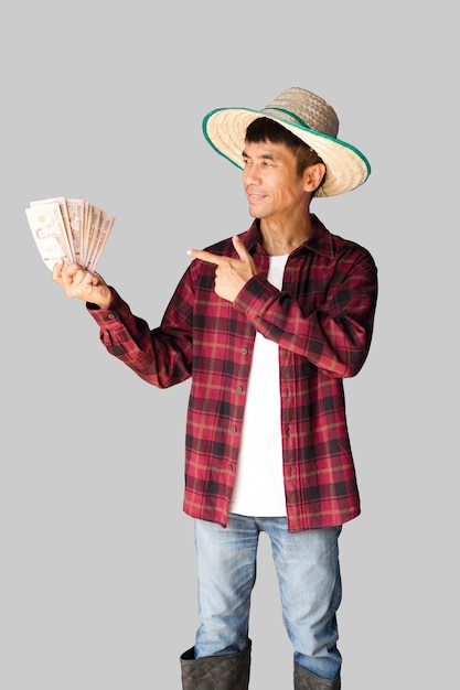 Un agricultor asiático masculino con una camisa roja de pie sosteniendo billetes Una toma de medio cuerpo Imagen de ruta de recorte aislada