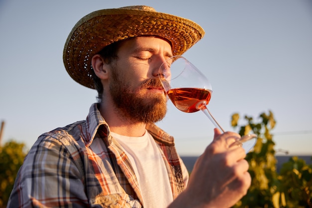 Agricultor bebendo vinho no vinhedo