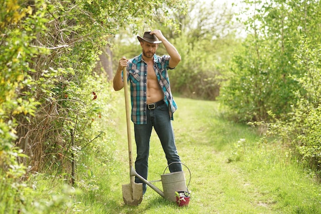 Agricultor en el campo Hombre agricultor en un paseo por un campo verde Agricultor agrícola después de la cosecha Agricultor sexy en tierras de cultivo