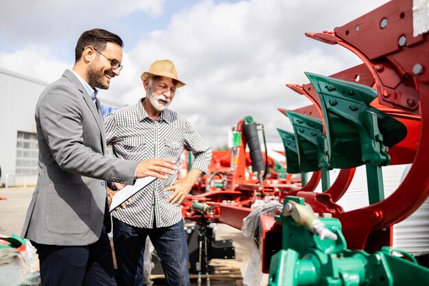 Foto agricultor comprando um novo equipamento de arado para seu trator