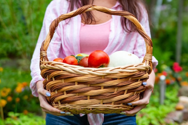 agricultor de mulher sorridente feliz sem rosto segurando uma cesta de legumes de sua horta. fechar sem rosto