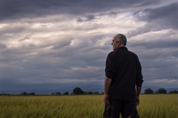 Agricultor en un día de tormenta viendo la cosecha