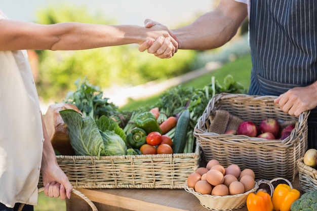 Agricultor e cliente apertando as mãos