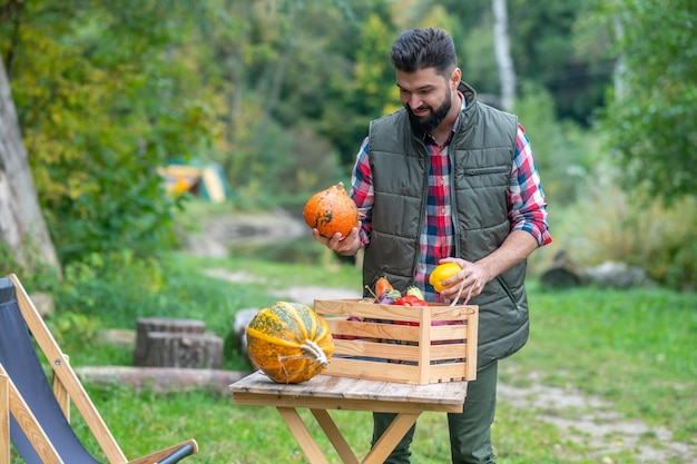 Agricultor em camisa xadrez classificando legumes e parecendo positivo