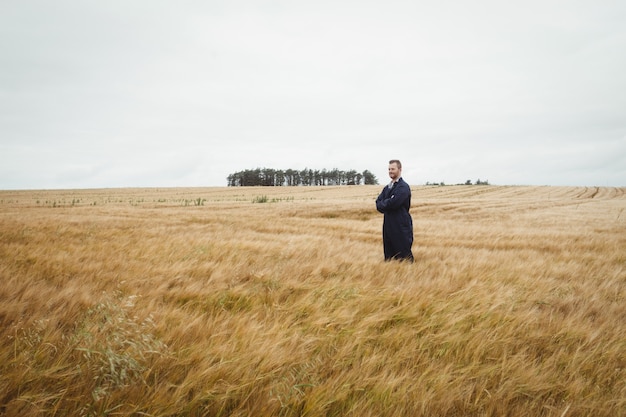 Agricultor em pé com os braços cruzados no campo