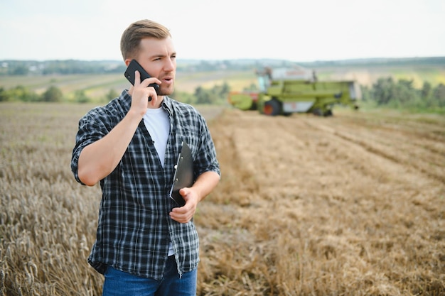 Agricultor em pé no campo de trigo na colheita