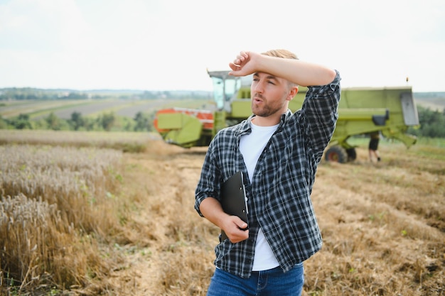 Agricultor em pé no campo de trigo na colheita