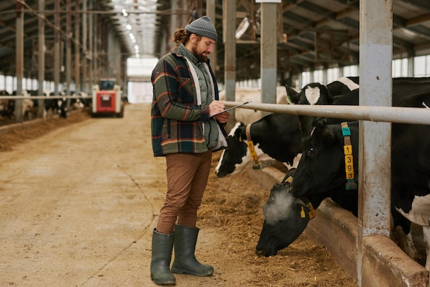 Agricultor escribiendo información sobre el estado de las vacas