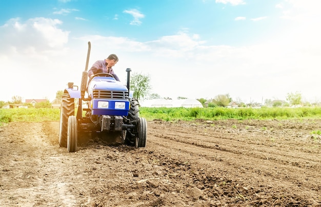 El agricultor está procesando tierra en un tractor.