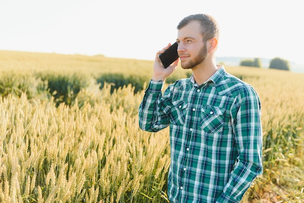 Agricultor falando ao celular no campo em um dia ensolarado