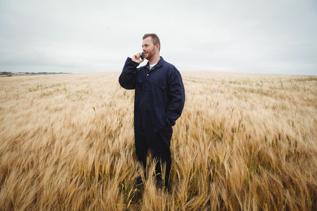 Agricultor falando no celular no campo