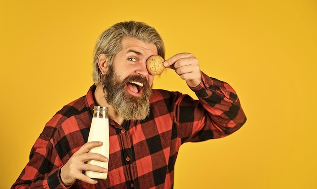 Agricultor feliz come sobremesa de biscoito homem barbudo bebe leite útil com pastelaria Biscoito de gengibre