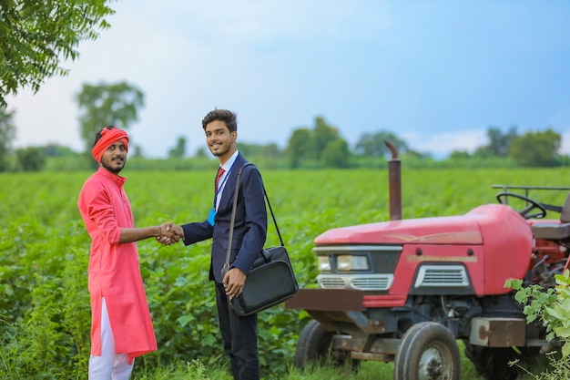 Agricultor indiano e banqueiro em pé no campo