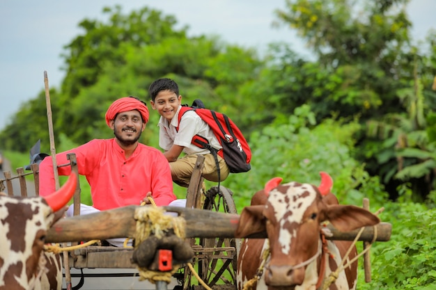 Agricultor indiano e seu filho em carro de boi