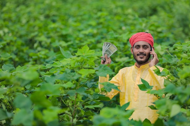 Agricultor indiano mostrando dinheiro em campo de algodão