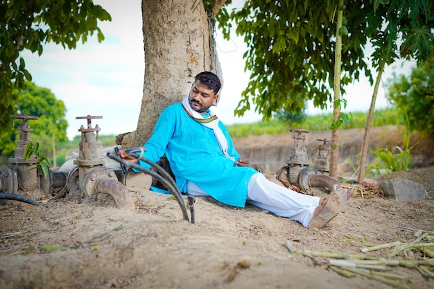 Agricultor indiano sentado confortavelmente no campo