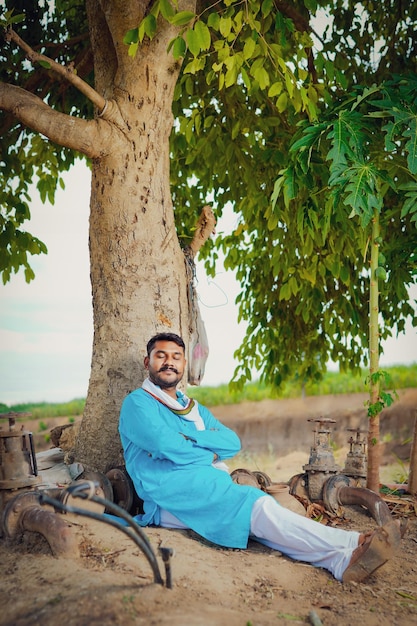 Agricultor indiano sentado confortavelmente no campo