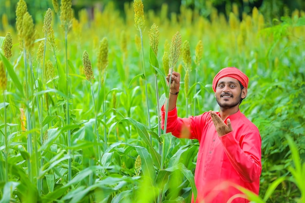 Agricultor indio de pie en un campo de sorgo