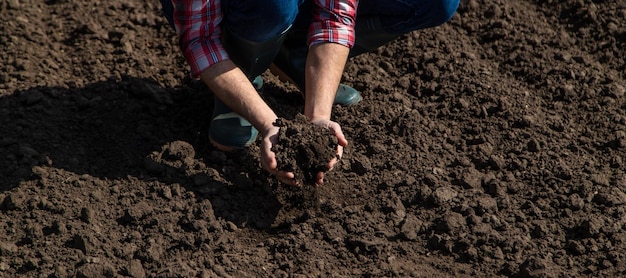 Agricultor masculino no campo verifica o foco seletivo do solo