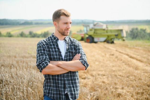 Agricultor no campo de trigo inspecionando o agricultor no campo de trigo com colheitadeira