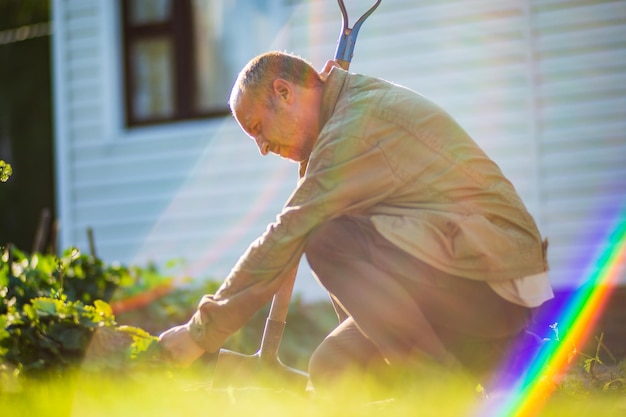 El agricultor con una pala en el jardín Preparando el suelo para plantar verduras Concepto de jardinería Trabajo agrícola en la plantación