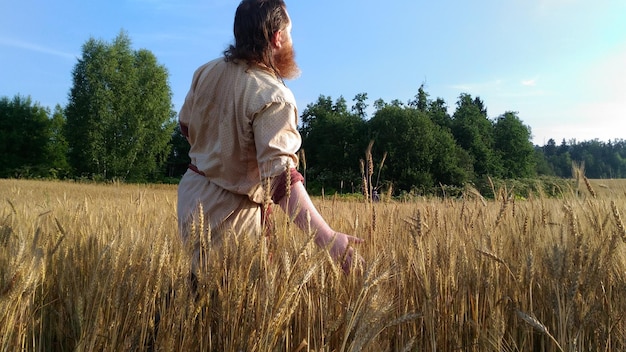 Agricultor de pie en medio de la cosecha de trigo en la granja