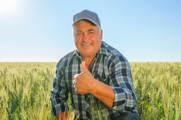 Agricultor positivo com o polegar para cima na zona rural