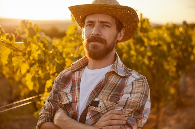 Agricultor sério em vinhedo à noite