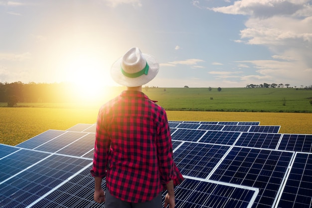 Agricultor sobre planta fotovoltaica de energía solar Granja solar al atardecer Espacio para texto