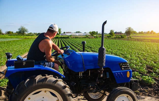 Agricultor trabalha no campo com trator agroindústria e agroindústria máquinas agrícolas