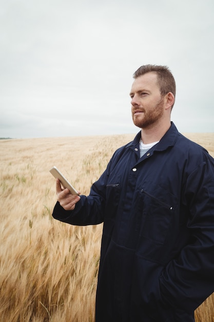 Agricultor usando telefone celular no campo