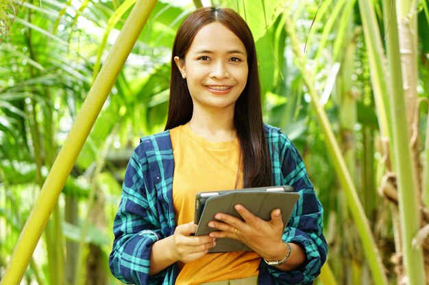 La agricultora está feliz después de ver los resultados de una computadora portátil Aumento de las ganancias Antecedentes de la plantación de banano