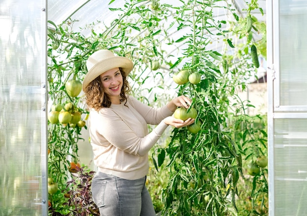 Una agricultora que trabaja en un invernadero orgánico. mujer, cultivo, vegetales