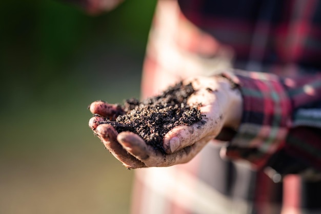 La agricultora sostiene el suelo en las manos monitoreando la salud del suelo en una granja en australia