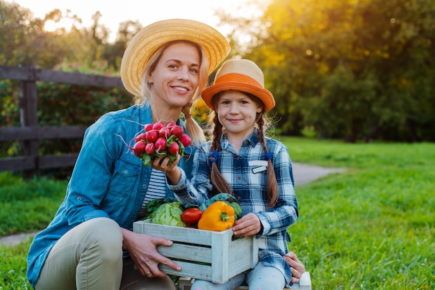 Agricultores mãe e filho segurar uma caixa de legumes