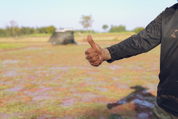 Los agricultores pulgares hacia arriba en el fondo del campo