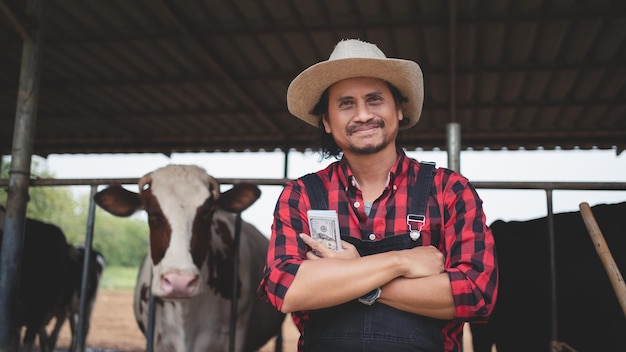 Agricultores sonrientes y felices obtienen ingresos de la granja lechera Industria agrícola Concepto de agricultura y ganadería Vaca en la granja lechera comiendo heno Establo