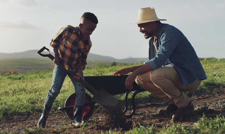 Foto agricultura agrícola y padre e hijo ayudan a la agricultura plantando verduras y cavando en el suelo familia negra naturaleza y padre con niño para el crecimiento sostenible y la agroindustria en el campo