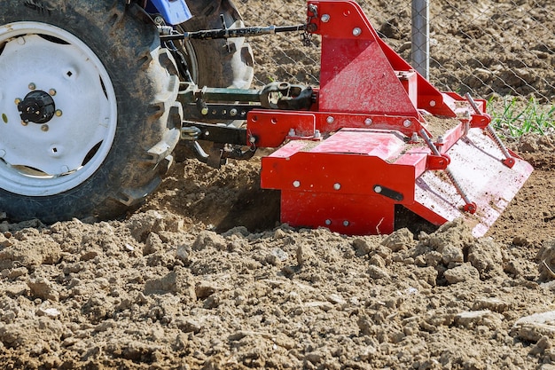 La agricultura a pequeña escala con tractor y arado en el campo