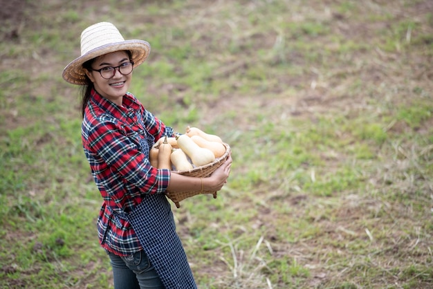 Agricultura, senhora jovem, sorrindo, feliz, com, butternut, squash, colheita, em, fazenda