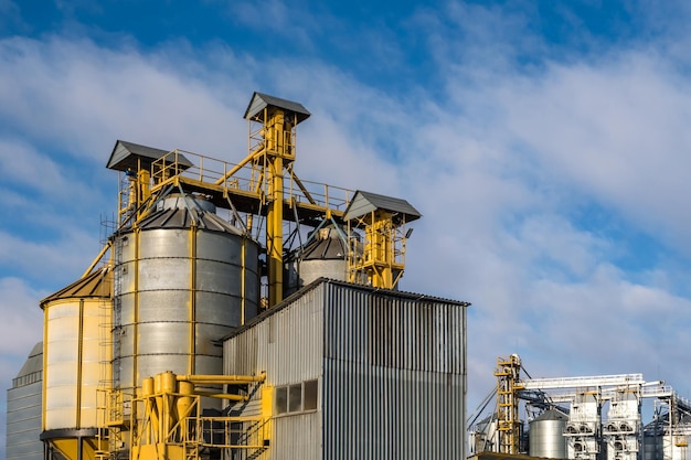 Agro-Silos-Getreideaufzug am Wintertag auf schneebedeckten Feldern Silos auf Agroprocessing-Produktionsanlagen zur Verarbeitung, Trocknung, Reinigung und Lagerung von landwirtschaftlichen Produkten, Mehl, Getreide und Getreide