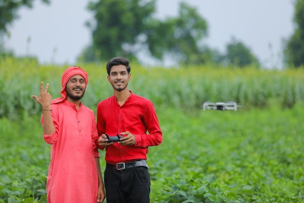 Agrónomo y agricultor indio con drone en el campo agrícola