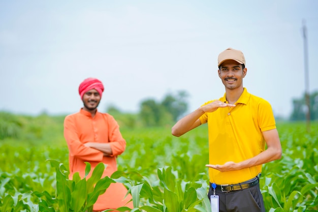 Agrônomo indiano com fazendeiro no campo de agricultura verde.