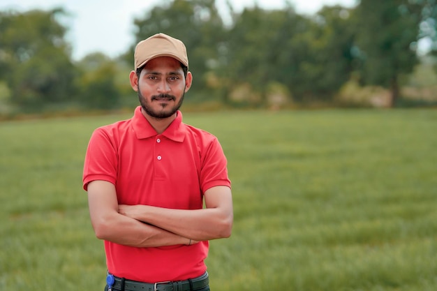 Agrônomo indiano dando expressão com a mão no campo da agricultura.